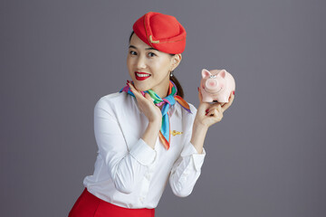 smiling modern asian female stewardess isolated on grey