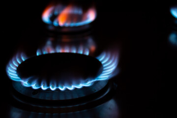 A gas burner with blue flames in the dark
