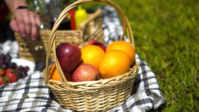 Hombre agarrando una naranja en la canasta de un picnic