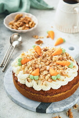 Easter Carrot cake with cream cheese frosting. Delicious carrot cake with walnut and cream cheese frosting on gray concrete background table for festive dinner. Traditional carrot cake. Easter food.