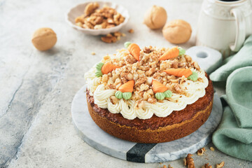 Fototapeta na wymiar Easter Carrot cake with cream cheese frosting. Delicious carrot cake with walnut and cream cheese frosting on gray concrete background table for festive dinner. Traditional carrot cake. Easter food.