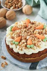 Easter Carrot cake with cream cheese frosting. Delicious carrot cake with walnut and cream cheese frosting on gray concrete background table for festive dinner. Traditional carrot cake. Easter food.