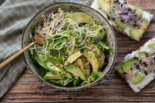 Vegan, detox Buddha bowl with avocado, spinach, micro greens, edamame beans, zucchini noodles and herb green dressing.