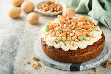 Easter Carrot cake with cream cheese frosting. Delicious carrot cake with walnut and cream cheese frosting on gray concrete background table for festive dinner. Traditional carrot cake. Easter food.