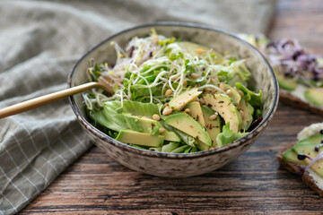Vegan, detox Buddha bowl with avocado, spinach, micro greens, edamame beans, zucchini noodles and...