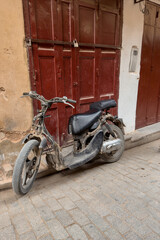 Fototapeta na wymiar An old motorbike parked on the street in the old medina of Fez, Morocco