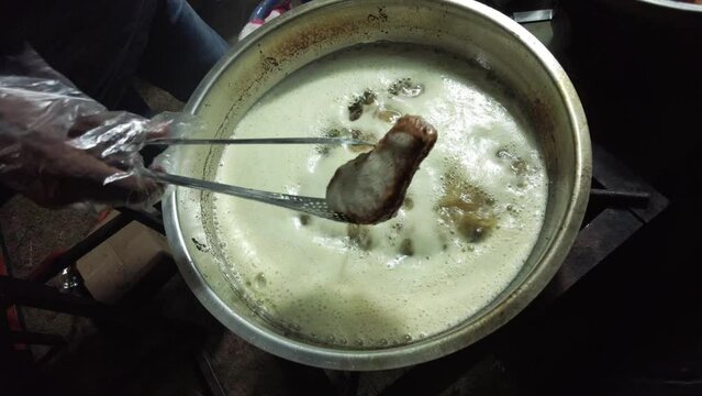 Boiling water with chicken in a pot on a hot stove. Boiling water from heating soup
