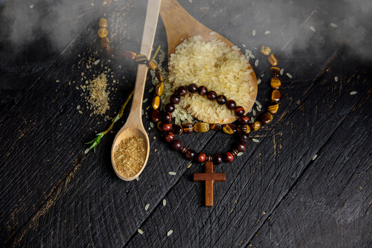 crucifix rosary and rice, Christian cross necklace on dark background - as a symbol of the beginning of Great Lent, Ash Wednesday	