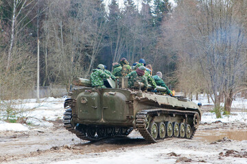 russian military tank with soldiers in ukraine in winter goes on the attack under fire