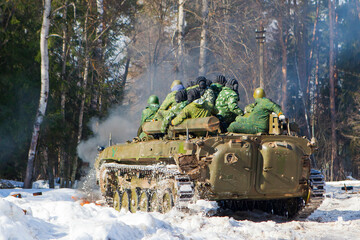 russian military tank with soldiers in ukraine in winter goes on the attack under fire