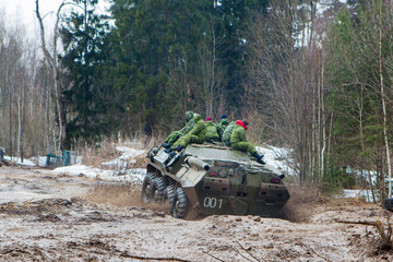 russian military tank with soldiers in ukraine in winter goes on the attack under fire