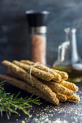 Italian grissini bread sticks with sesame seeds on kitchen table.