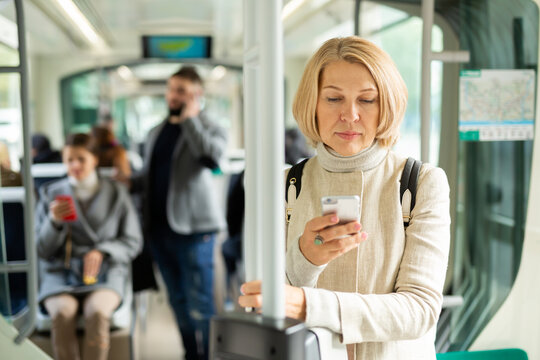 Portrait of female passenger using mobile phone in tram. High quality photo