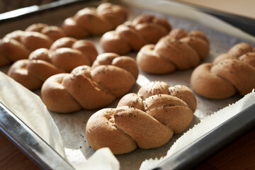 Homemade braided bread buns or rolls made of whole grain spelt flour