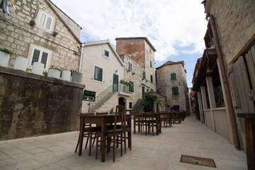 empty street with restaurants and cafes in croatian historic town of hvar on an island without tourists - obrazy, fototapety, plakaty