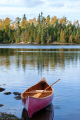 Wooden canoe near shore of Boundary Waters lake in Minnesota on an autumn morning