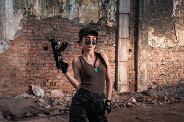 Fototapeta premium Female soldier with weapons. Character from the comic book The Punisher. Armed with a pistol and machine gun. A dangerous person who solves problems with force.