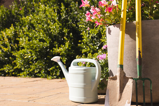 Close up of watering can, shovel and rake in garden