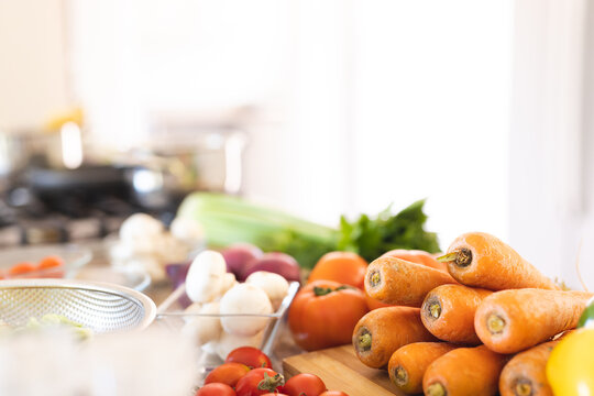 Countertop with fresh tomatoes, carrots, mushrooms and celery in kitchen - Powered by Adobe