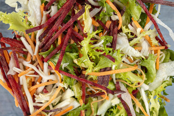 Fresh vegetables salad in the bowl above dark moody blue background