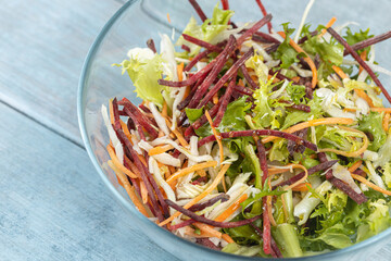 Fresh vegetables salad in the bowl above dark moody blue background