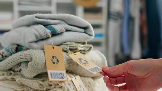 Sorted material, Active woman sorts products materials Caring person Touches holds a tag Bright jackets and pants Close-up Girl activist Prepares to recycle in a clothing warehouse, wardrobe
