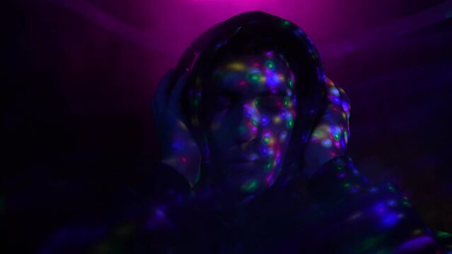 Portrait Guy in Headphones Listens to a Song and Enjoys in Neon Lighting and Color Music. 