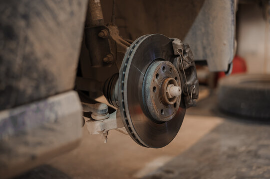 Car brake part in the garage, car brake disc without wheels. Car suspension. Current car repair
