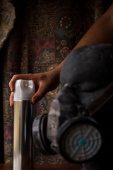 Fototapeta na wymiar Hand taking an aerosol can next to an antigas mask on manikin