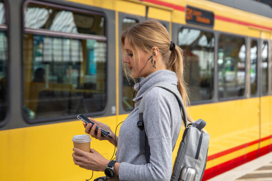 Nahaufnahme einer jungen Frau vor einem Zug im Bahnhof