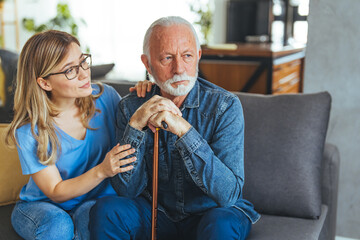 Shot of a female healthcare worker comforting elderly man at home. A woman carer concerned about an...