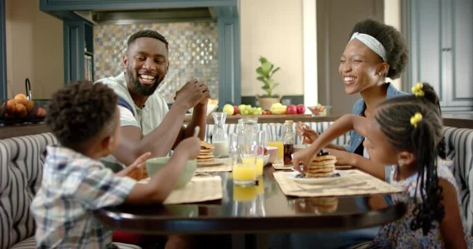 Happy african american family having breakfast, in slow motion