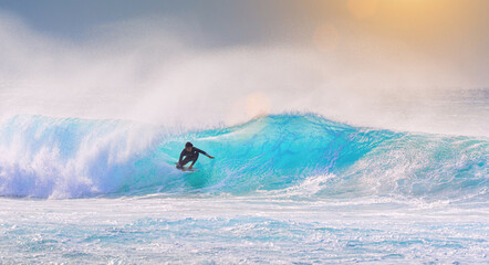 young adult surfing on a big wave in the ocean