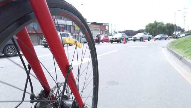 Bicycle tire or wheel spinning on a ride around the city of Bogota with cars and cyclists in the streets during the ciclovia