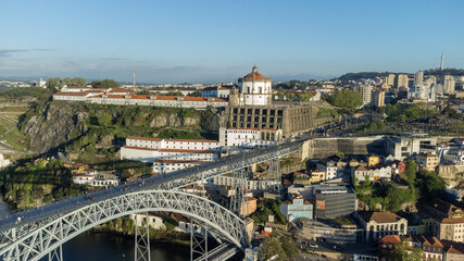 Naklejka premium Oporto, Portugal. April 13, 2022: Luis bridge and yellow tram with blue sky.