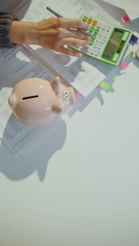 tax time. piggy bank and accountant woman with calculator and documents working in office.