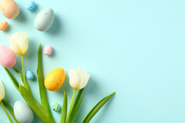 easter eggs and tulips on pastel blue table