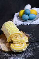 delicious vanilla cake roll with lemon butter cream inside, dark grey marble table