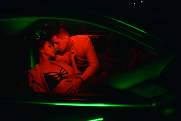 sexy couple in red light in the car with grainy