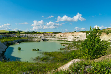 Fototapeta na wymiar A large sand quarry and a lake. A flooded old abandoned quarry complex. Extraction of sand and stone for industrial applications.