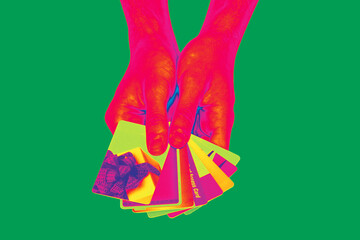 Psychedelic look hands holding a set of credit and gift cards isolated on green