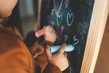 Children draw on the board with chalk