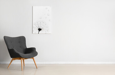 Fototapeta Stylish grey armchair and beautiful painting near white wall obraz