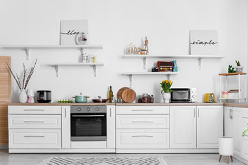 Interior of kitchen with Easter decor, white counters and shelves