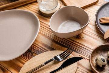 Beautiful table setting with plates, bowl and cutlery on wooden background