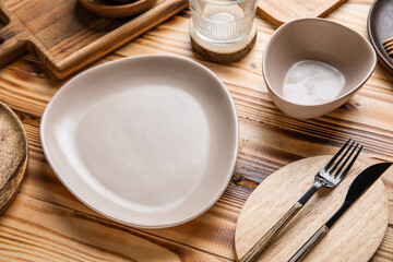 Beautiful table setting with plates, bowl and cutlery on wooden background