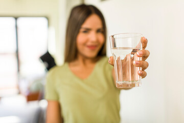 pretty latin woman with a water glass at home