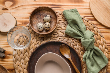 Fototapeta na wymiar Beautiful table setting with plates, bowl and quail eggs on wooden background