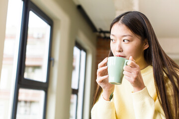 asian pretty woman with a coffee cup at cool home