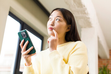 asian pretty woman using a smartphone in a cool home